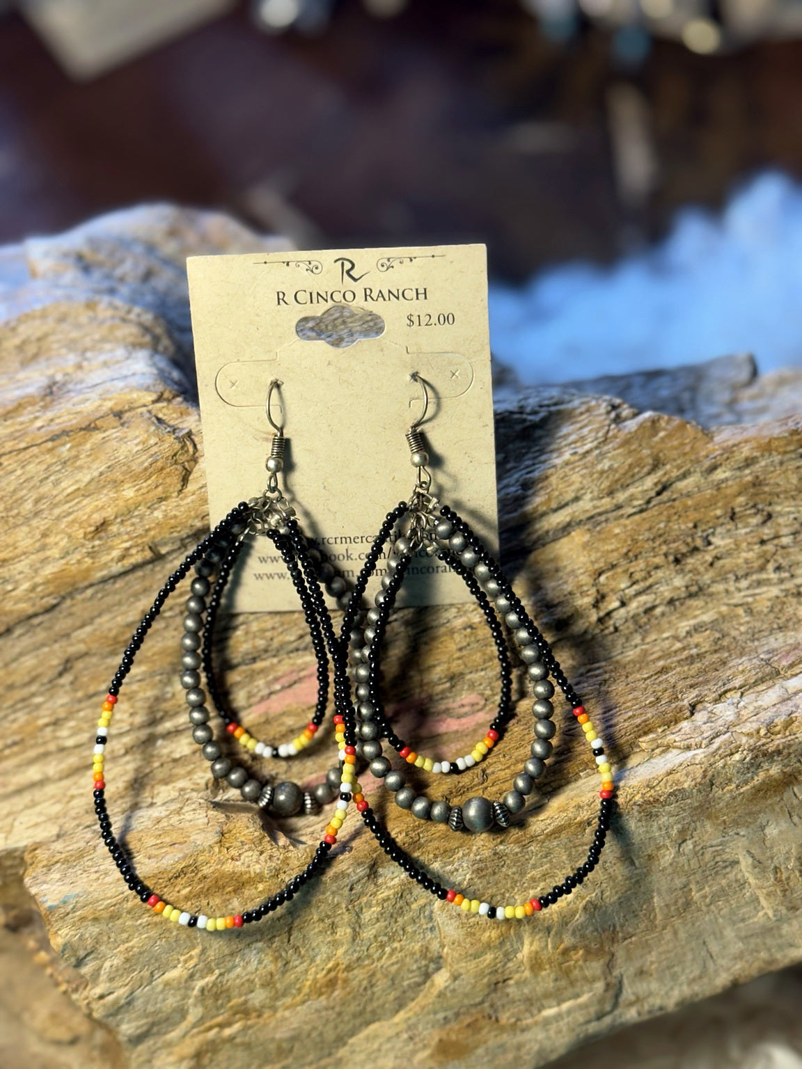 Long black seed bead hoop earrings with gunmetal-tone beads and red, yellow, and white accents
