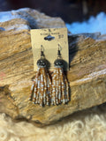 Black seed bead earrings with long cream, tan, and white fringe strands