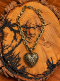 Antique Gold-Tone Western Scroll Heart Necklace on rustic wood