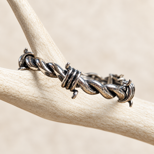 Antiqued silver-tone barbed wire stretch bracelet on a white antler display