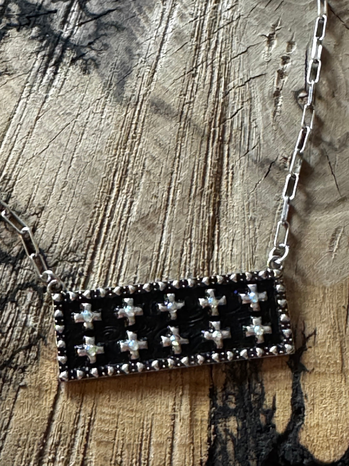 Close-up of black statement necklace with rhinestone-centered silver-tone crosses