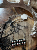 Black rectangular statement necklace with raised silver-tone bubble accents