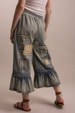 Back angled view showing patches and ruffled hems on Blue Velvet pants