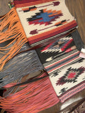 Three custom made saddle blanket bags with colorful woven patterns and fringe