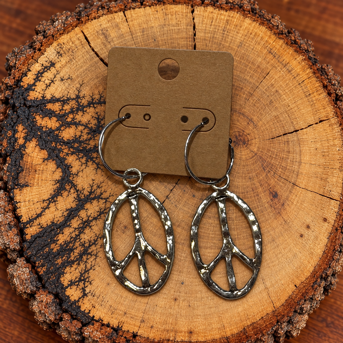 Hammered Oval Peace Sign Hoop Earrings on a plain kraft card