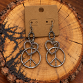 Silver-Tone Crystal Heart and Peace Sign Drop Earrings on a plain kraft card