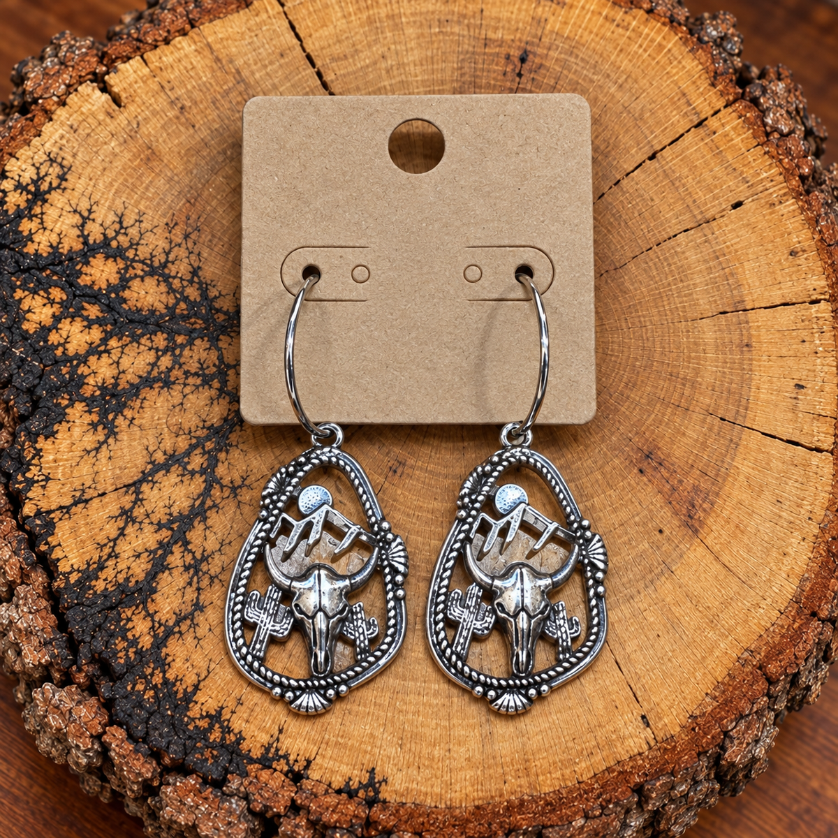 Silver-Tone Steer Skull Desert Teardrop Hoop Earrings on a plain kraft card