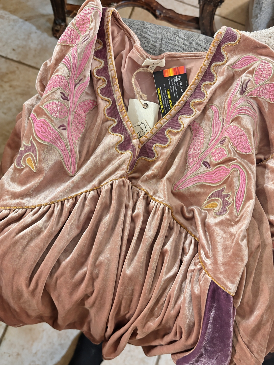 Embroidered velvet tunic with pink floral details and purple trim, brightened photo