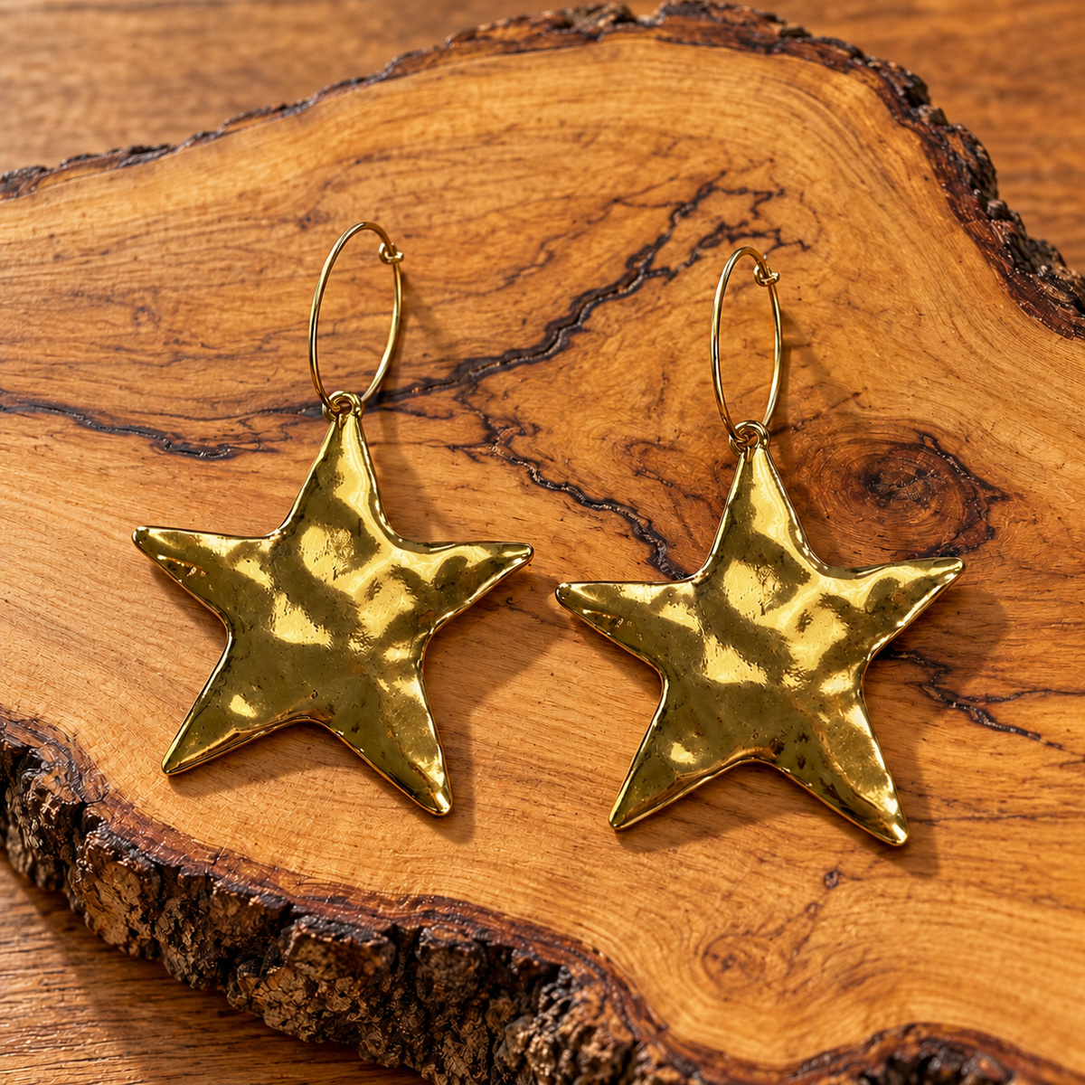Gold-Tone Hammered Star Hoop Earrings on wood