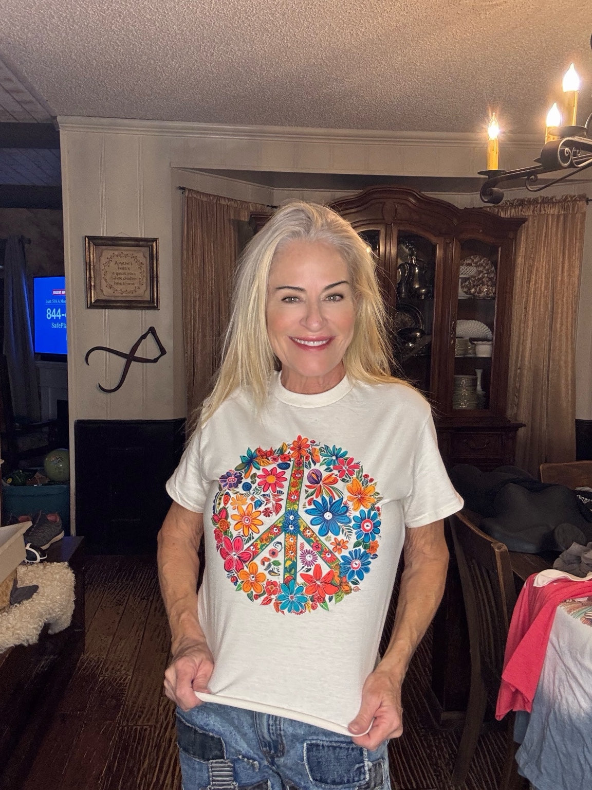 Cream tee with a colorful floral peace sign graphic.