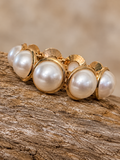 Gold-tone pearl-look stretch bracelet on rustic wood