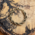 gold-tone twisted rope chain bracelet on rustic wood