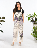 Model wearing the Grape vintage feed sack wide-leg jumpsuit with a black tee and neutral slip-on shoes