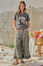 Model wearing Guts, Grit and Lipstick tee with BIBI camouflage ruffle hem wide-leg pants