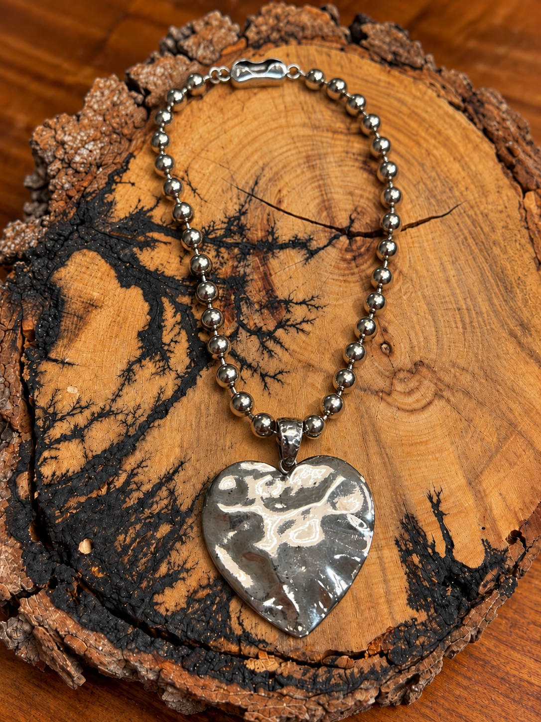 Hammered Silver-Tone Heart Necklace on rustic wood
