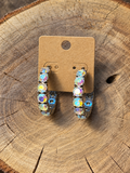 Iridescent crystal hoop earrings on a plain kraft card