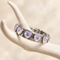Pale iridescent heart crystal bracelet in antiqued silver-tone settings on a white antler