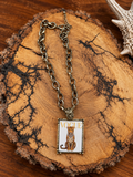 Leopard portrait rectangular pendant necklace on a rustic wood slice