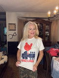 Cream tee with a distressed red bird, navy guitar, and Peace & Music lettering.