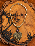 Pearl-Look Gold-Tone Double Heart Necklace on rustic wood