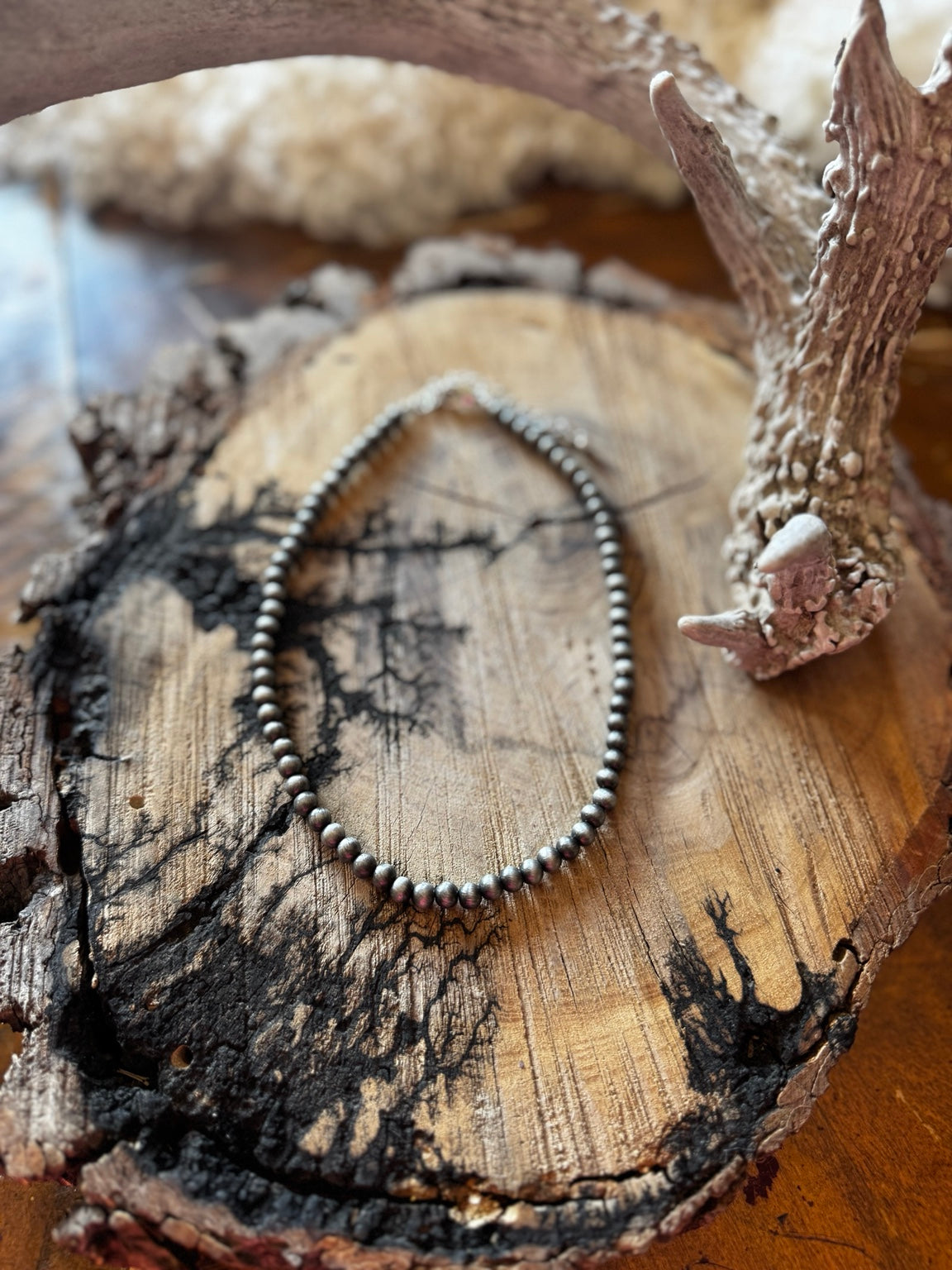 Petite gunsmoke silver-tone Navajo pearl-style beaded necklace on rustic wood