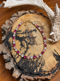 Pink and clear round crystal link necklace on a rustic wood slice