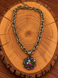 Rainbow Crystal Flower Necklace – Antique Gold-Tone Chain on warm golden wood