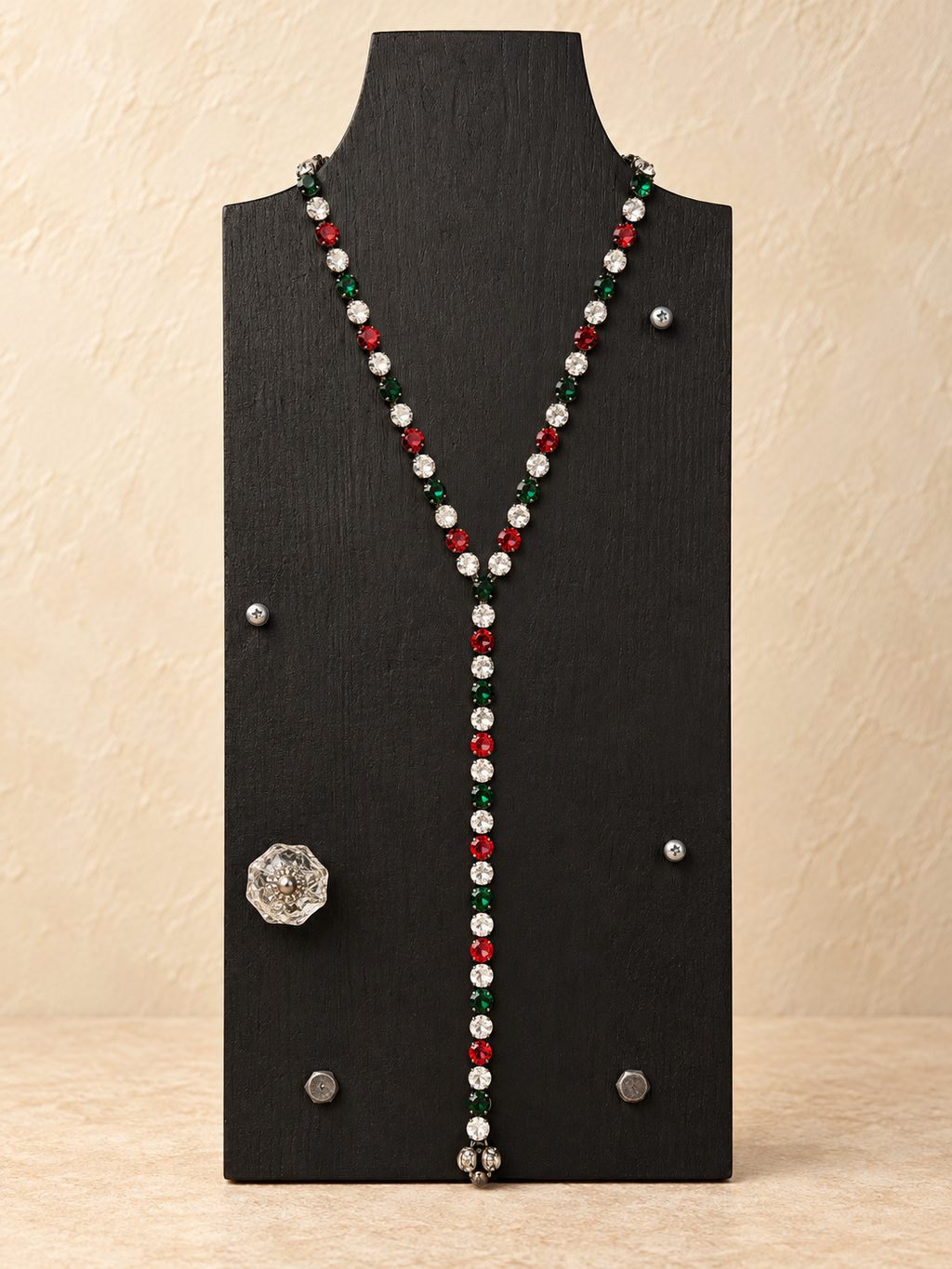 Red, green and clear crystal magnetic Y necklace styled with a medium drop on a black stand