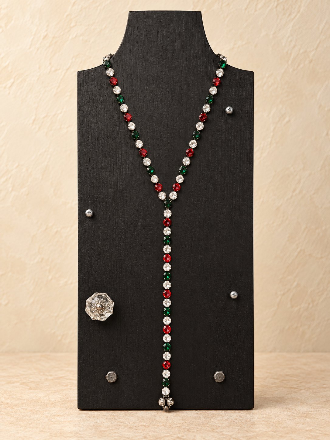 Red, green and clear crystal magnetic Y necklace styled with a medium drop on a black stand