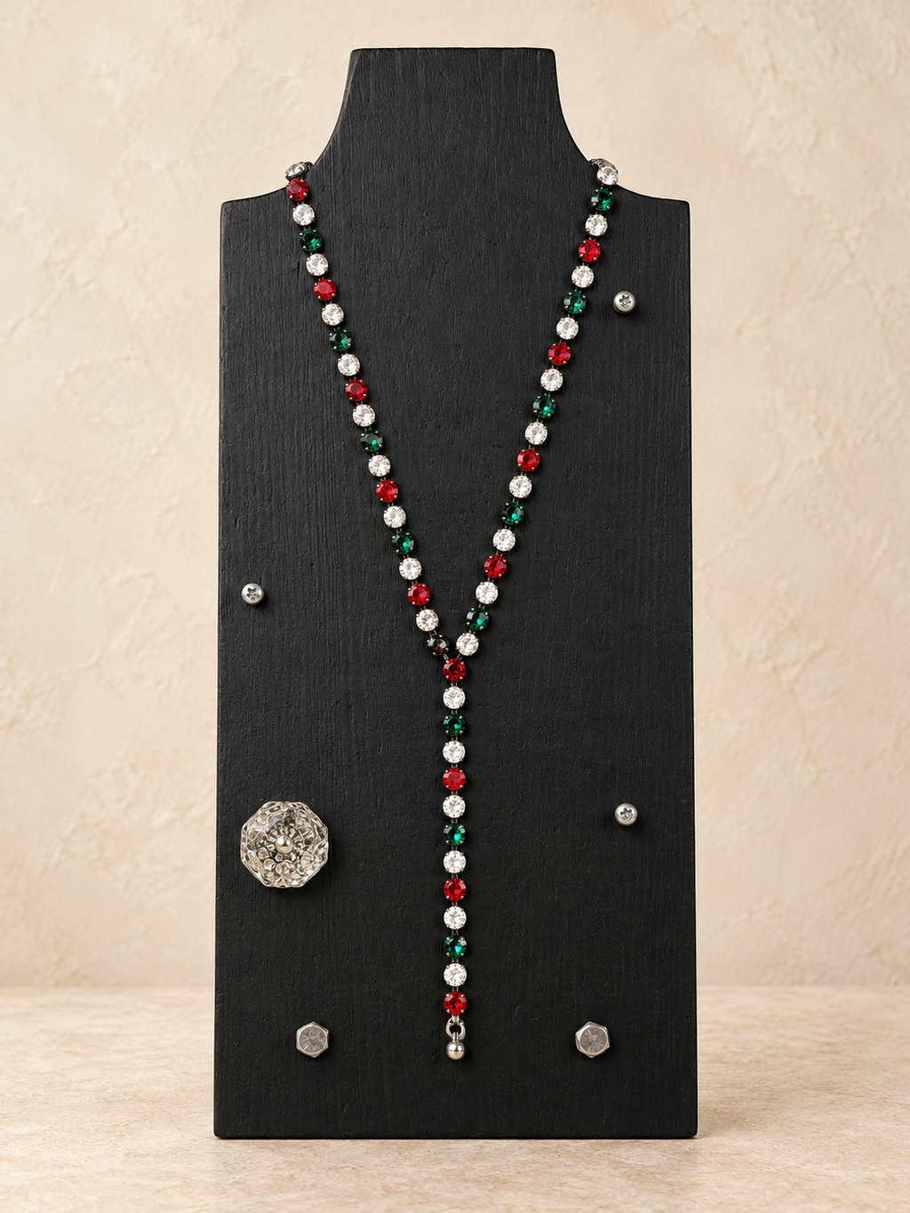 Red, green and clear crystal magnetic Y necklace styled with a short drop on a black stand