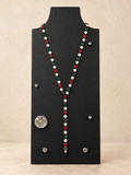 Red, green and clear crystal magnetic Y necklace styled with a short drop on a black stand