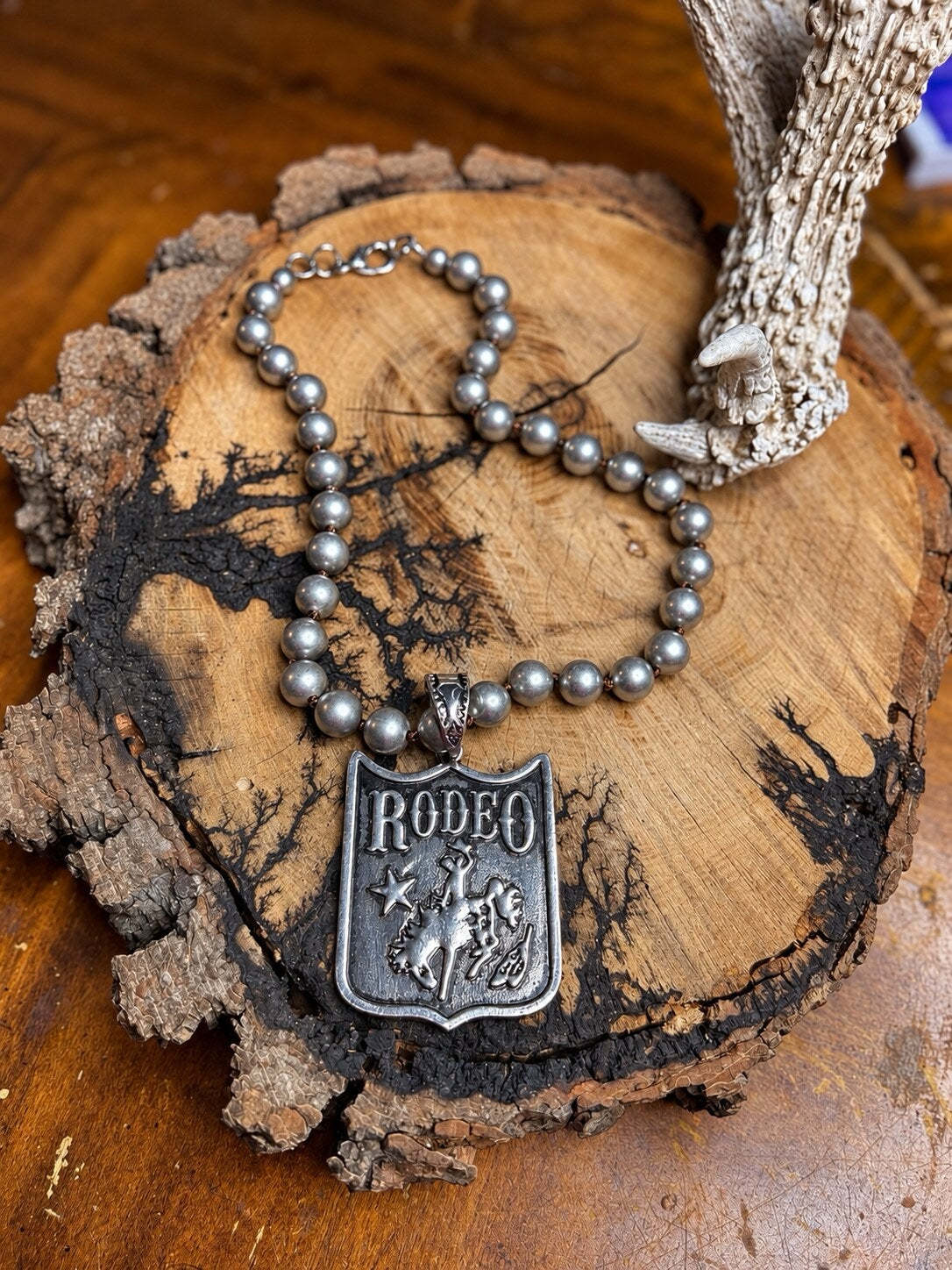 Silver-tone rodeo shield pendant necklace with hand-knotted silver metal beads