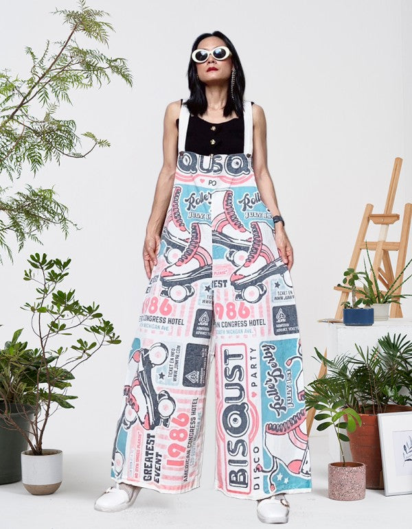 Model wearing the Roller Skate vintage feed sack wide-leg jumpsuit with white sneakers