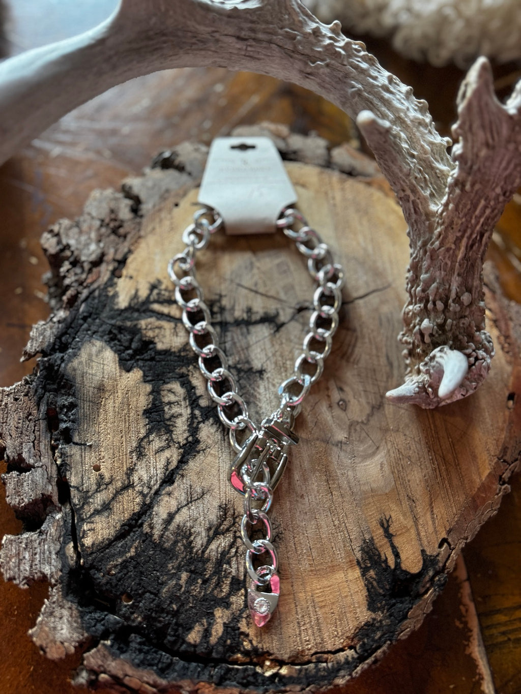 Silver-tone chunky chain necklace with buckle accent styled on rustic wood