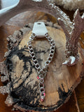 Silver-tone chunky chain necklace with buckle accent styled on rustic wood