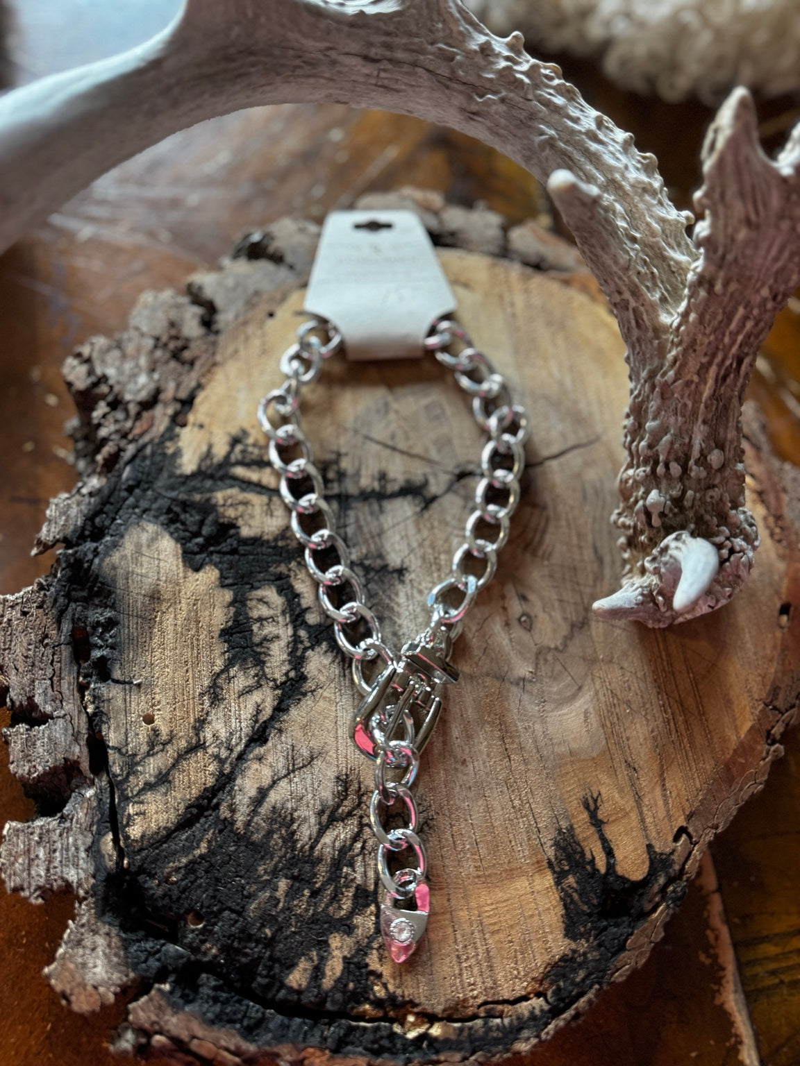 Silver-tone chunky chain necklace with buckle accent styled on rustic wood