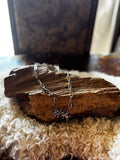 Silver-tone running horses necklace styled on rustic wood and wool
