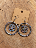 Silver-tone iridescent crystal star hoop earrings on a plain kraft card and wood