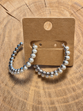 Silver-tone pearl-look hoop earrings on blank kraft card and natural wood