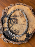 Silver-tone twisted rope chain necklace on rustic wood display