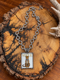 Silver-tone Vogue leopard pendant necklace with oval-link chain on rustic wood