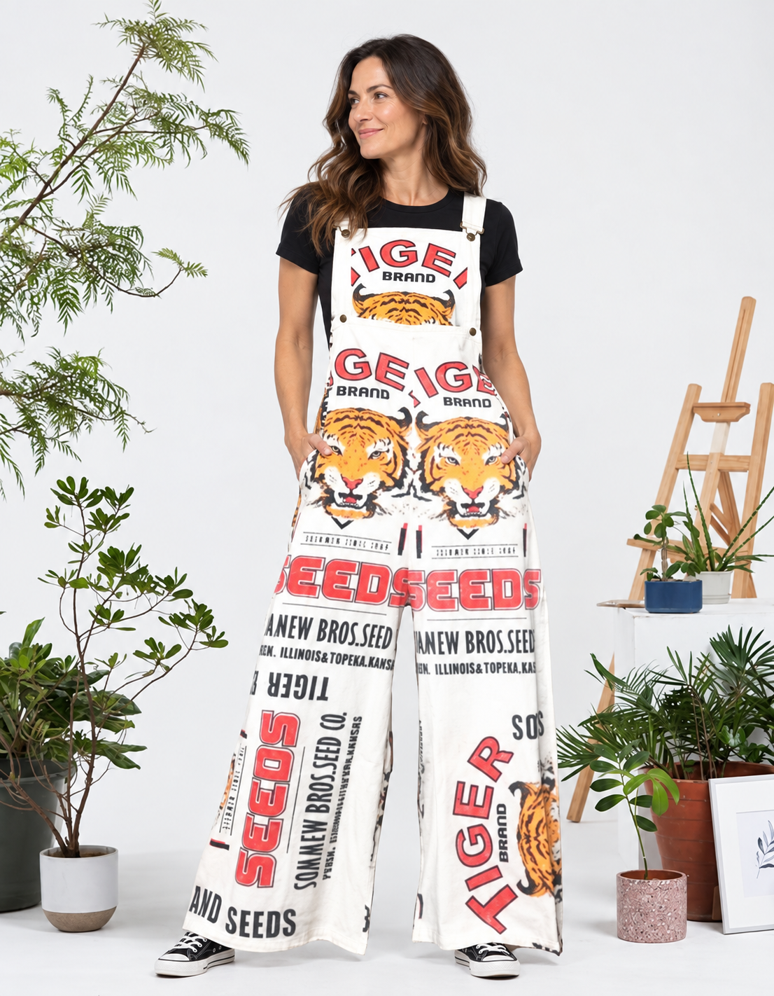 Model wearing the Tiger vintage feed sack wide-leg jumpsuit with a black tee and black sneakers