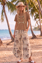 Model wearing Saddle Story cowboy print tulip pants with Triple Threat snaffle bit crop tee