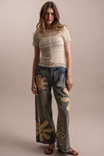 Wildflower patchwork wide-leg denim pants styled full-length front view
