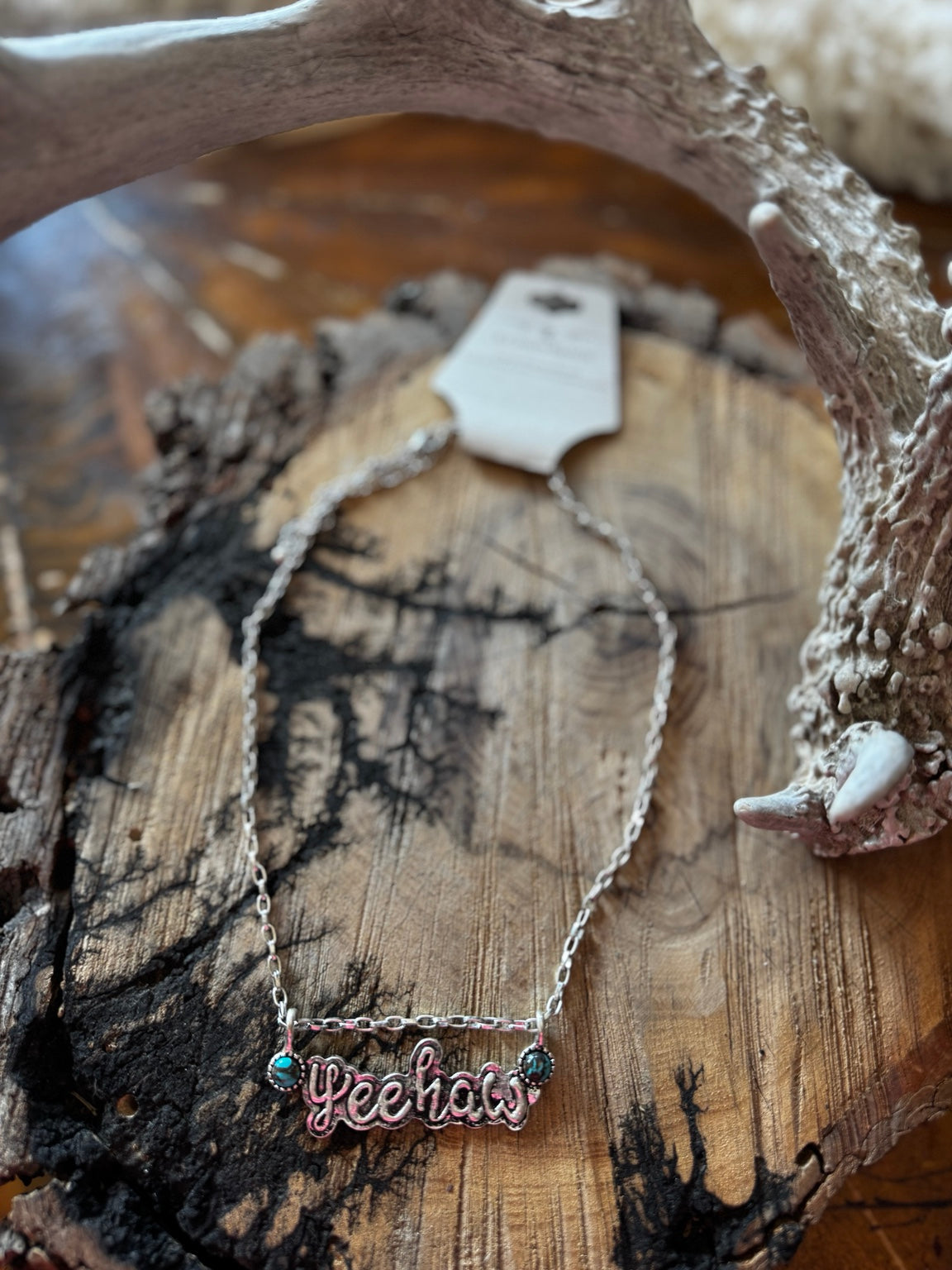 Silver-tone Yeehaw script necklace with turquoise-colored accents